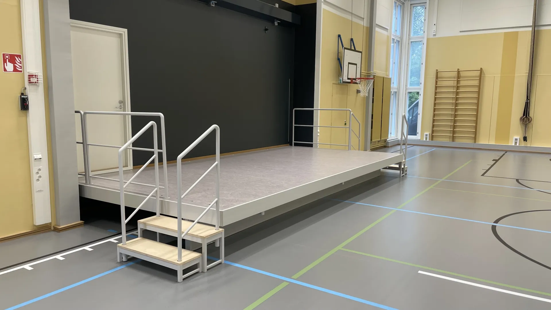 Koulun liikuntasalissa seinälle kääntyvä näyttämö
